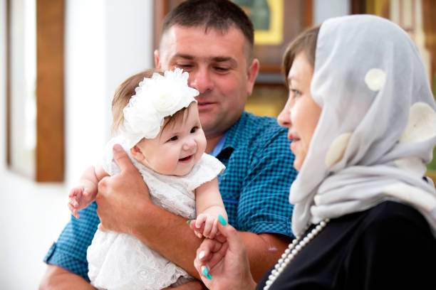 Baptism of the child. Godfathers with a child. Baptism of the child. Godfathers with a child. godfather godparent stock pictures, royalty-free photos & images