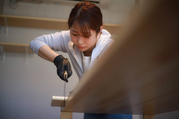 istock DIY image of a woman cutting a tree with a saw 1315126398