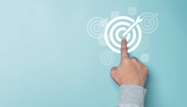 Hand touching white target board on blue background and copy space , Setup business goal and objective achievement concept.