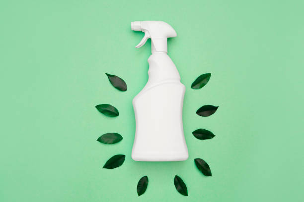 istock Ecological object. Eco-friendly, natural cleaning products concept. White bottle with a spray bottle and green leaves around on a green background 1315128950