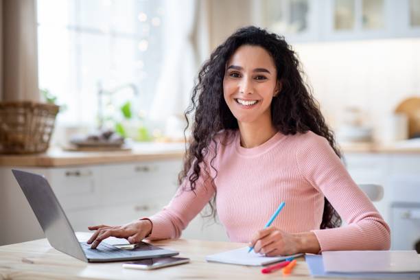 istock Work From Home. Happy Young Freelancer Lady Working With Laptop In Kitchen 1315128985