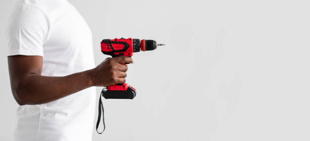 istock Unrecognizable black handyman holding drill or electric screwdriver, isolated on white background 1315129230