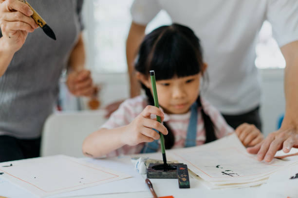 young girl writing chinese calligraphy at home - chinese script text calligraphy grandmother imagens e fotografias de stock