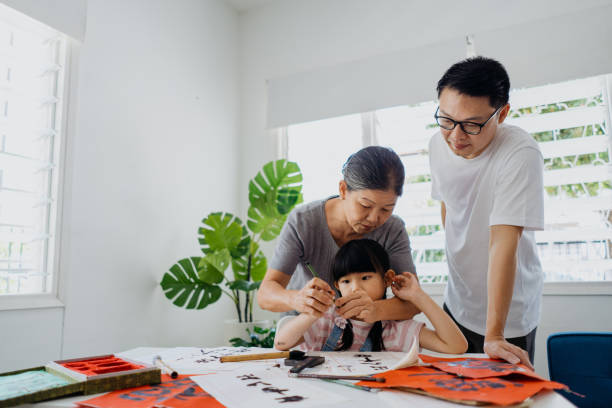 asian chinese family practicing chinese calligraphy at home - chinese script text calligraphy grandmother imagens e fotografias de stock