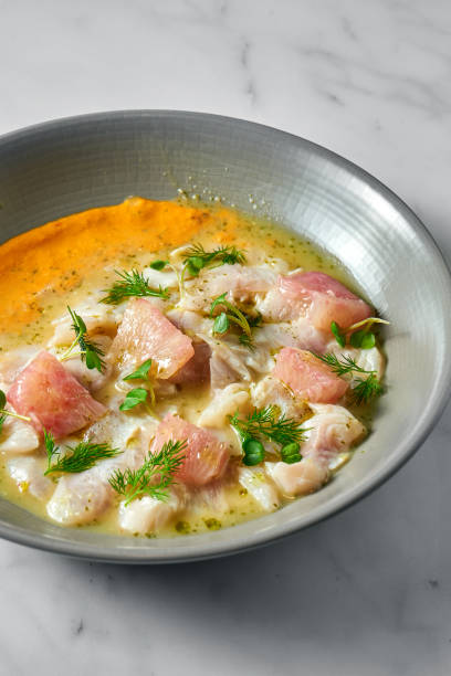 istock Peruvian cuisine dish - seabass ceviche with grapefruit and yellow sauce, served in a grey plate on a marble background. Restaurant seafood. 1315129926
