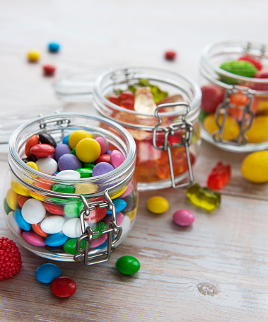 Colorful candies, jelly and marmalade in jars on the table
