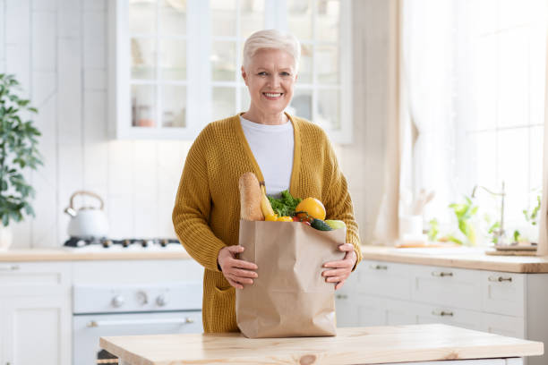 istock Happy senior woman with grocery bag ordered from internet 1315131439