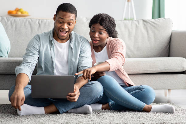 istock Amazed african american couple using laptop at home 1315131634