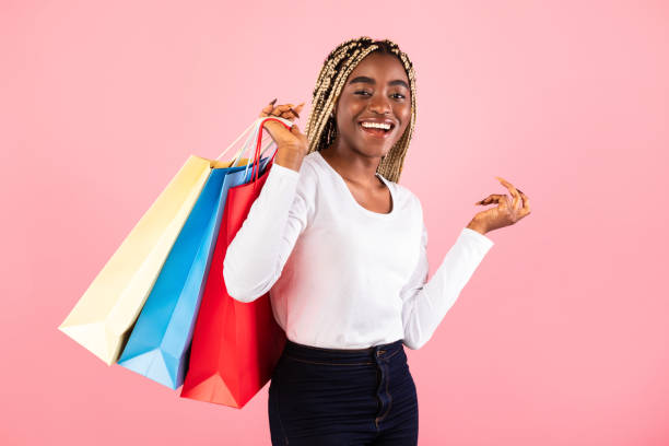 istock Black lady holding shopping bags at pink studio wall 1315131714