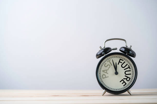 istock Alarm clock running for change from past to future on wooden table with copy space. 1315131735