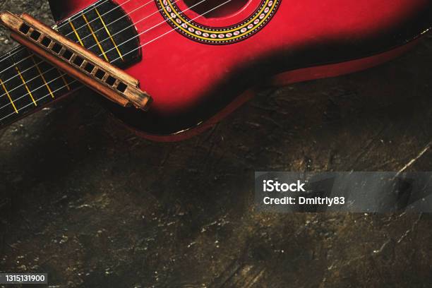 Old Harmonica And A Red Guitar On A Dark Abstract Background Musical Instrument Stock Photo - Download Image Now