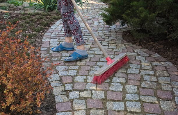 istock Sweeping a granite paving path in the spring garden 1315132733