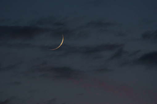 crescent moon with thin clouds on the evening sky