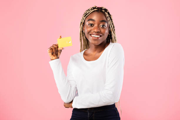 mujer negra mostrando tarjeta de crédito y sonriendo - greeting card holding women credit card fotografías e imágenes de stock