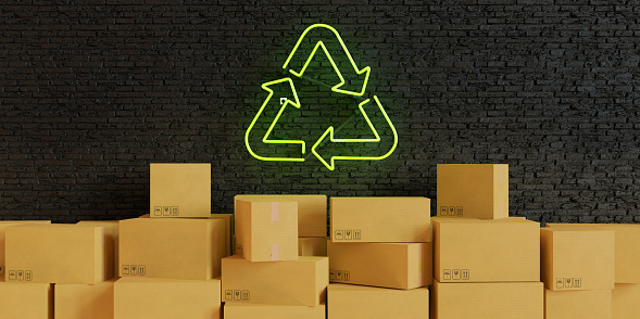 Cut or torn green cardboard paper with recycling symbol background isolated on white