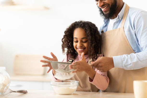 istock Cheerful black man and his daughter preparing dough 1315139041
