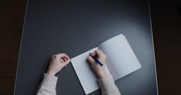 istock Woman is writing in a note pad. Personal perspective 1315139925