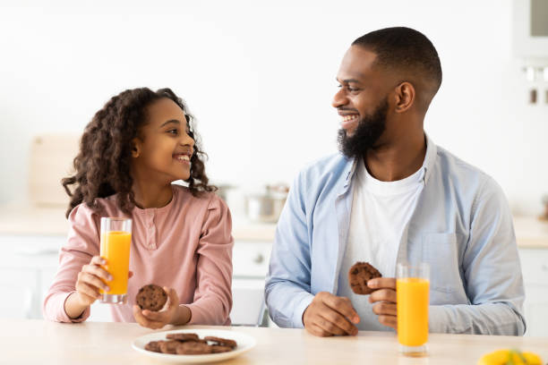 istock Cheerful african american daughter and dad having breakfast 1315140847