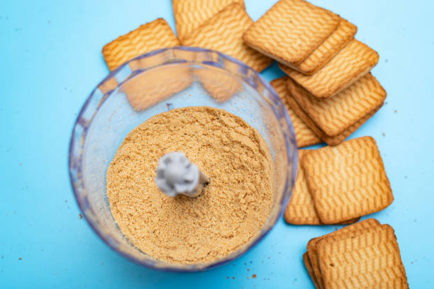 grinding cookies in a blender on a blue background. making a dessert from shortbread cookies. - close up cookie gourmet food imagens e fotografias de stock