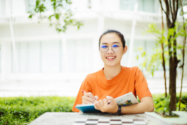 retrato de nerd asiática mujer inteligente adolescente feliz sonriendo con gafas en green park al aire libre en el campus universitario con copyspace - nerd student female exam fotografías e imágenes de stock