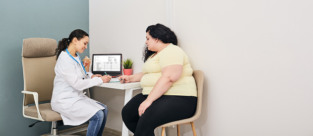 Consulta dietista. Mujer visita nutricionista para tratamiento de obesidad photo