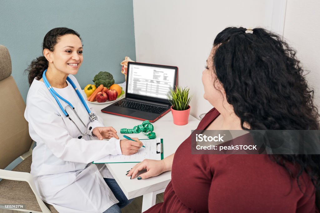 Nutritionist consultation. Dietitian plans meal plan for a female obese patient Nutritionist Stock Photo