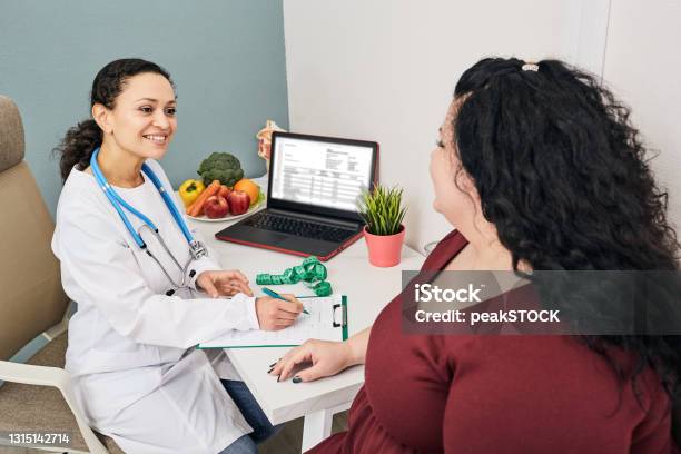 Nutritionist Consultation Dietitian Plans Meal Plan For A Female Obese Patient Stock Photo - Download Image Now