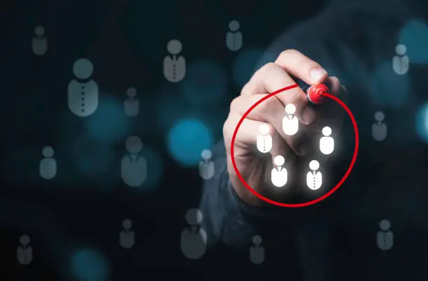 Photo of Businessman drawing red circle to marking and select human icons , Human development or marketing focus customer target group.
