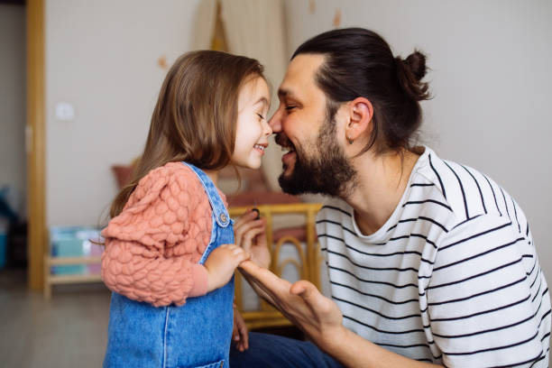 Responsible good father helping her little daughter get dressed, preparations for school