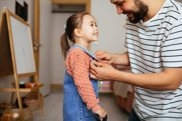 istock Responsible good father helping her little daughter get dressed, preparations for school 1315145118