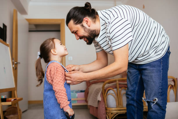 istock Responsible good father helping her little daughter get dressed, preparations for school 1315145199