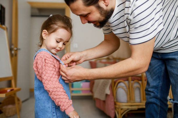 istock Responsible good father helping her little daughter get dressed, preparations for school 1315145817