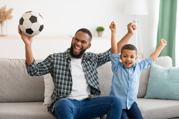 istock Joyful Daddy And Son Watching Soccer Game On TV Indoor 1315146258