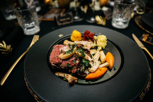 Black plate with steak , mushrooms and carrots