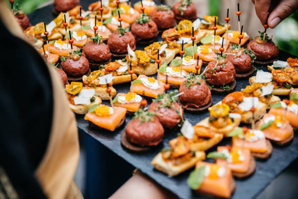 kellnerin serviert verschiedene vorspeisen auf einem schiefer - bread cheese bruschetta canape stock-fotos und bilder