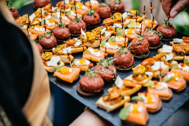 Waitress serving different appetisers on a slate Waitress serving different appetisers on a slate including baguette with smoked salmon and black bread with meatballs appetizer stock pictures, royalty-free photos & images