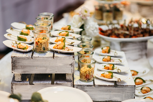 Glasses with couscous and prawn skewers as appetisers on a buffet