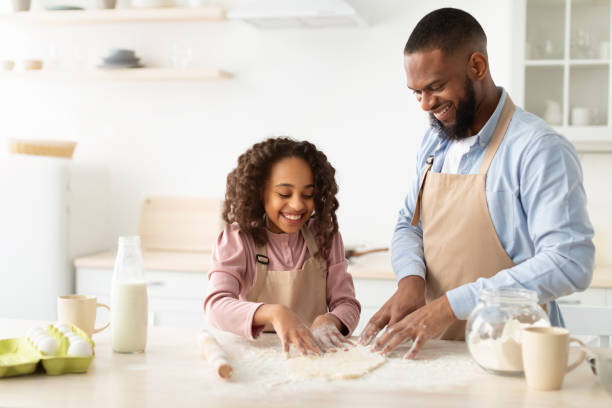 istock Cheerful afro man and his child daughter kneading dough 1315147952