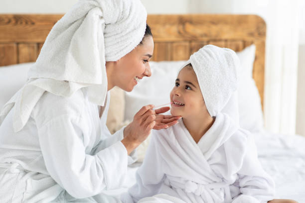 istock Mom putting make up on her cute little daughter 1315148506