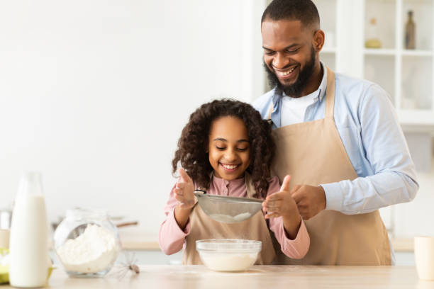 istock Cheerful afro man and his daughter preparing dough 1315148666