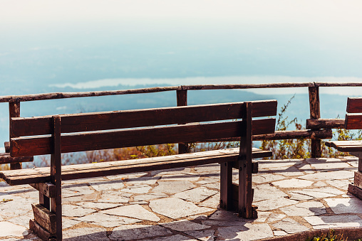 Wooden bench in Piazzale Belvedere, Campo dei Fiori, with glimpse of Varese Lake