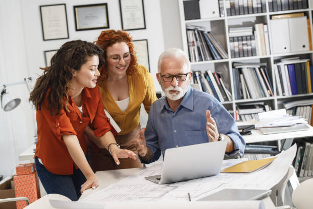 istock Senior designer manager explaining to his female coworkers how to solve problem. 1315151299