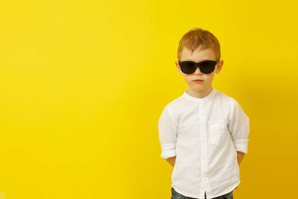 istock A boy in sunglasses poses on a yellow background 1315151365