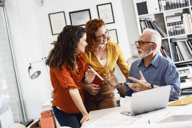 istock Senior designer manager explaining to his female coworkers how to solve problem. 1315152005