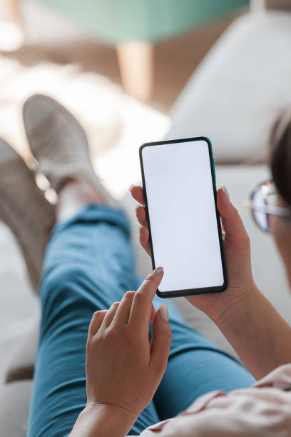 istock Woman hold mobile phone in hands, lying on sofa 1315155324
