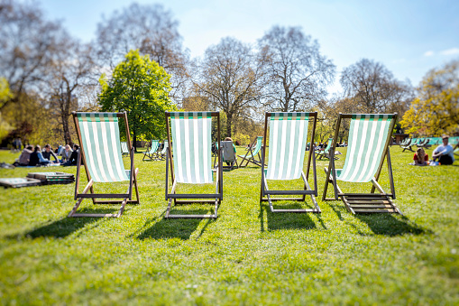 Four empty deck chairs in St. James Park London, UK