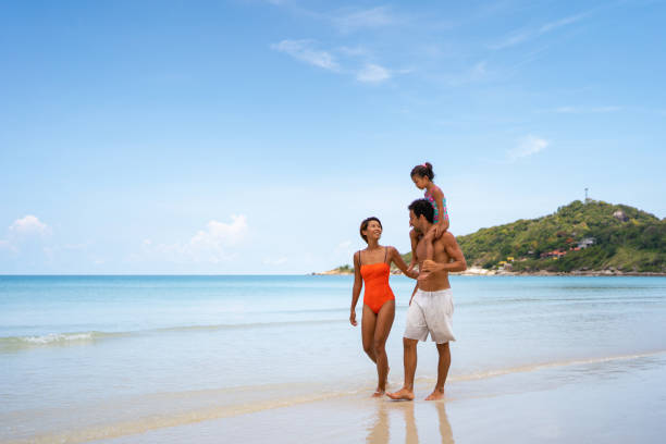 istock Happy family walking on the beach 1315156499
