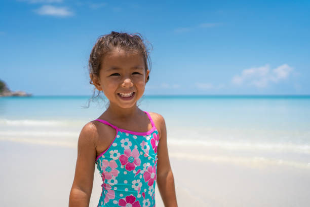 Portrait of cute smiling girl standing near the sea.