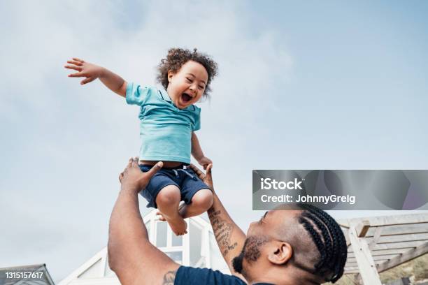 Young Boy With Down Syndrome Expressing Joy In Midair Stock Photo - Download Image Now