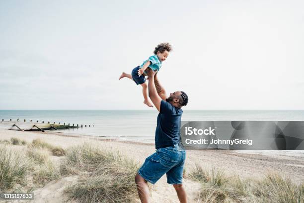 Father And Son Enjoying Vacation Playtime At Camber Sands Stock Photo - Download Image Now